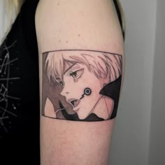 a woman's arm with an anime character tattoo on the left side of her body