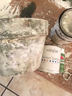 a can of valpspar next to some paint and a brush on the floor