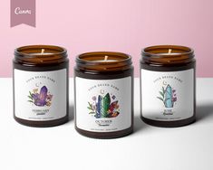 three candles sitting next to each other on top of a white table with a pink background