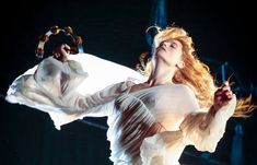 a woman in white dress performing on stage