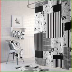 a bathroom with black and white tiles on the wall, shower curtain and rugs