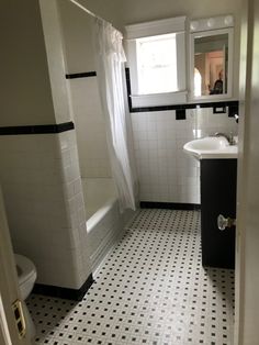 a bathroom with black and white tile flooring