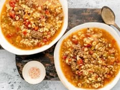 two bowls filled with soup on top of a cutting board