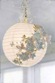 the paper lantern is decorated with flowers and butterflies on it's sides, along with other images