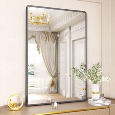 there is a mirror on the dresser in this room with gold trimmings and white walls