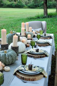 the table is set with pumpkins and candles