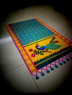 a brightly colored rug on the floor with pom poms