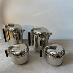 a set of four stainless steel pots and pans