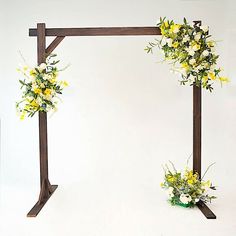 two wooden stands with flowers on them against a white background, one holding a bouquet of yellow and white flowers