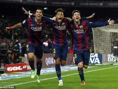 three soccer players are celebrating on the field