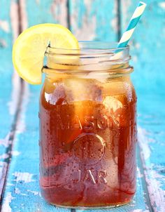 a mason jar filled with liquid and a lemon wedge