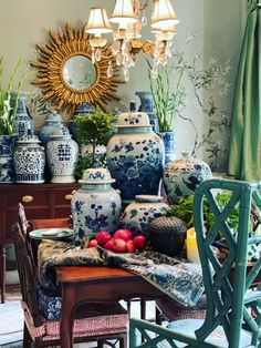 a dining room with blue and white vases sitting on top of a wooden table