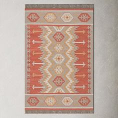 an orange and grey rug hanging on a wall