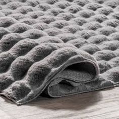 a close up of a rug on the floor with a wooden floor in the background