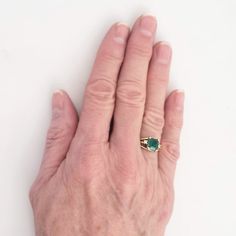 "This magnificent vintage ring boasts a lovely emerald and two diamonds set in 18K yellow gold. The emerald has a rich bluish-green color and weighs in at 1 1/4 carats. An accent diamond is set on each side of the emerald, adding elegance and sparkle. The ring has triple branched shoulders that add interest beyond the classic shank. Luxurious! Vintage: 1990s Size: 6 Materials: 18K Yellow Gold, Emerald, Diamonds Marked: 18K Emerald: 7 mm x 7mm x 4.4mm, approx. 1.25 ct. 2 Diamonds: brilliant cut, Timeless Green Emerald Ring With Accent Stones, Classic Green Emerald Ring With Accent Stones, Timeless Green Emerald Birthstone Ring, Vintage Green Emerald Ring With Brilliant Cut, Classic Green Sapphire Ring With Brilliant Cut, Classic Green Emerald Ring As Birthstone, Heirloom Emerald Ring Baguette Cut, Heirloom Style Baguette Cut Emerald Ring, Heirloom Baguette Cut Emerald Ring