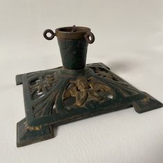 an old cast iron vase sitting on top of a stand