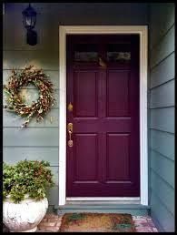 a purple front door with a wreath on it