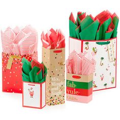 four small gift bags with red and green paper on them, each containing different designs