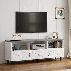 a flat screen tv sitting on top of a white entertainment center