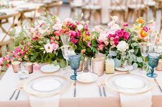 the table is set with flowers and plates