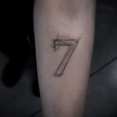 a tattoo with the number seven drawn on it's leg, in black ink