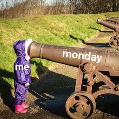 an old cannon with the word monday written on it and a small child standing next to it