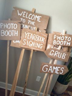 several wooden signs that say welcome to the photo booth, yearbook sign, and game