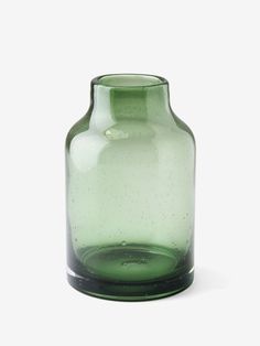 a green vase sitting on top of a white table