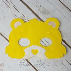 a yellow teddy bear mask sitting on top of a wooden floor