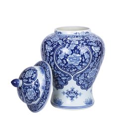 a blue and white vase with lid sitting next to another one on a white background