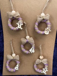 four christmas wreaths hanging from twine with snowman and ghost decorations on them