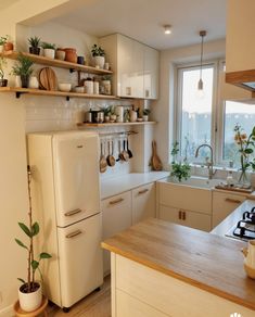 a white refrigerator freezer sitting inside of a kitchen next to a sink and stove