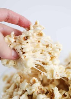 someone is scooping popcorn out of a glass bowl