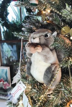 a stuffed animal sitting on top of a christmas tree