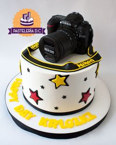 a birthday cake with a camera and stars on the top, for a photographer's special occasion