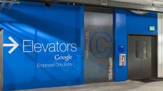 the entrance to elevators is painted blue and has an arrow pointing up at it's center