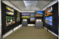 a room with several pictures on the wall and in front of it is a white tent