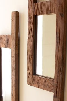 two wooden mirrors mounted to the side of a wall