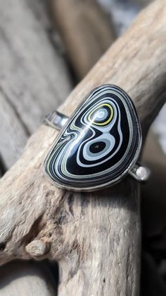 Fordite ring,size 9, bezel set in sterling silver. I spend hours designing and handcrafting every piece of my jewelry. It's very rewarding for me when I start with just sterling silver sheet and wire, and make it into a unique and one of a kind piece of jewelry.  There is a picture of what I start with when I create a new piece. If you would like additional pictures, please let me know and I will take some more. What is fordite?   Here's the story behind it. Years ago at a Ford plant, as the cars were painted, the overspray would build up on the racks and shelves in the paint booth. Eventually it was removed and  employees brought some home and polished it up in much smaller pieces. Then others discovered it and started creating things with it. That's where fordite got it's name. It's a ge Racks And Shelves, Fordite Ring, Paint Booth, Piece Of Me, Me When, Bezel Setting, Rings Statement, Black N Yellow, Sterling Silver Ring