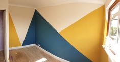 an empty room with blue, yellow and white paint on the walls is shown in this image