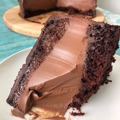 a piece of chocolate cake on a plate with one slice cut out and the rest half eaten