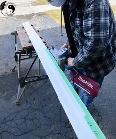 a man in plaid shirt sanding on top of a table