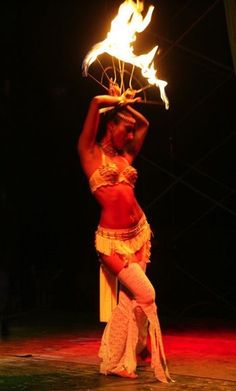 a woman is performing with fire in her hands