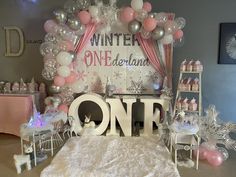 a room filled with balloons and decorations for a baby's first birthday