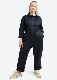 The Riveter Jumpsuit is crafted in soft Cotton Tencel blend with a touch of stretch. Details include tonally blue contrast stitching, adjustable side waist tabs with enclosed elastic back, two front utility chest pockets and pockets at the front hip. A button front closure with a covered placket keep this jumpsuit sleek. Fits true to size. Fitted Blue Jumpsuit With Side Pockets, Blue Utility Jumpsuit With Button Closure, Blue Utility Jumpsuits And Rompers For Work, Blue Jumpsuits And Rompers For Work With Button Closure, Blue Jumpsuit With Button Closure For Work, Fitted Jumpsuits And Rompers With Side Pockets For Work, Blue Jumpsuits And Rompers With Side Pockets For Work, Blue Workwear Jumpsuits And Rompers With Side Pockets, Blue Workwear Jumpsuit With Side Pockets