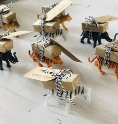 several small toy animals wearing boxes with zebras and tigers on them, all tied up