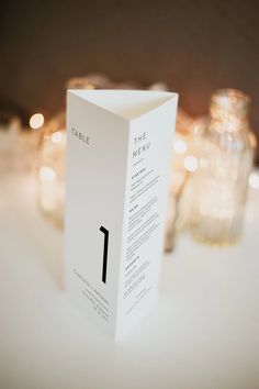 a table with candles and a menu card on it that reads the table number 1