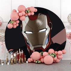 an iron man birthday party with balloons, candles and confetti sticks in front of it