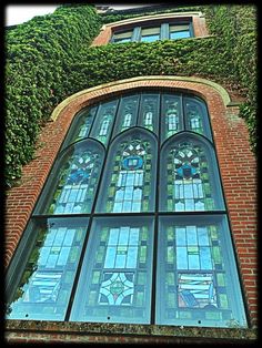 an old building with stained glass windows and ivy growing up the side