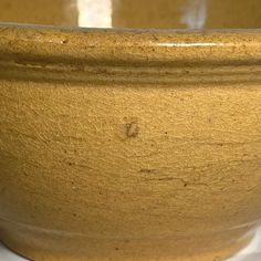 a brown bowl sitting on top of a white table